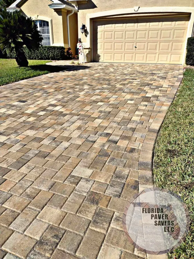 Brown and gray paver driveway leading to a garage