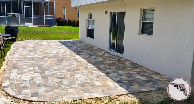 Paver patio with a rounded outer edge alongside a home