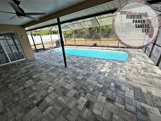 Paver pool deck extending into a covered outdoor seating area