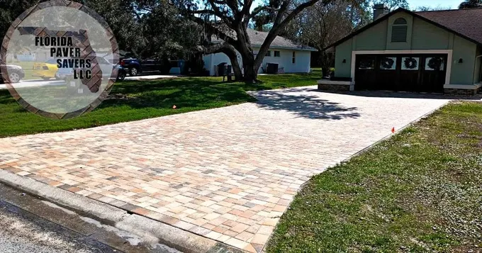 Light multicolor paver driveway leading from the road to a detached garage
