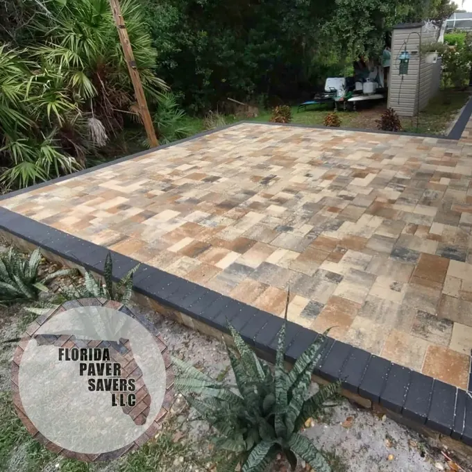 Raised multicolor paver patio with a charcoal border beside a garden in Hudson