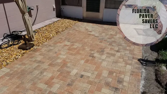 Warm tan paver patio outside rear doors with a gravel planting border